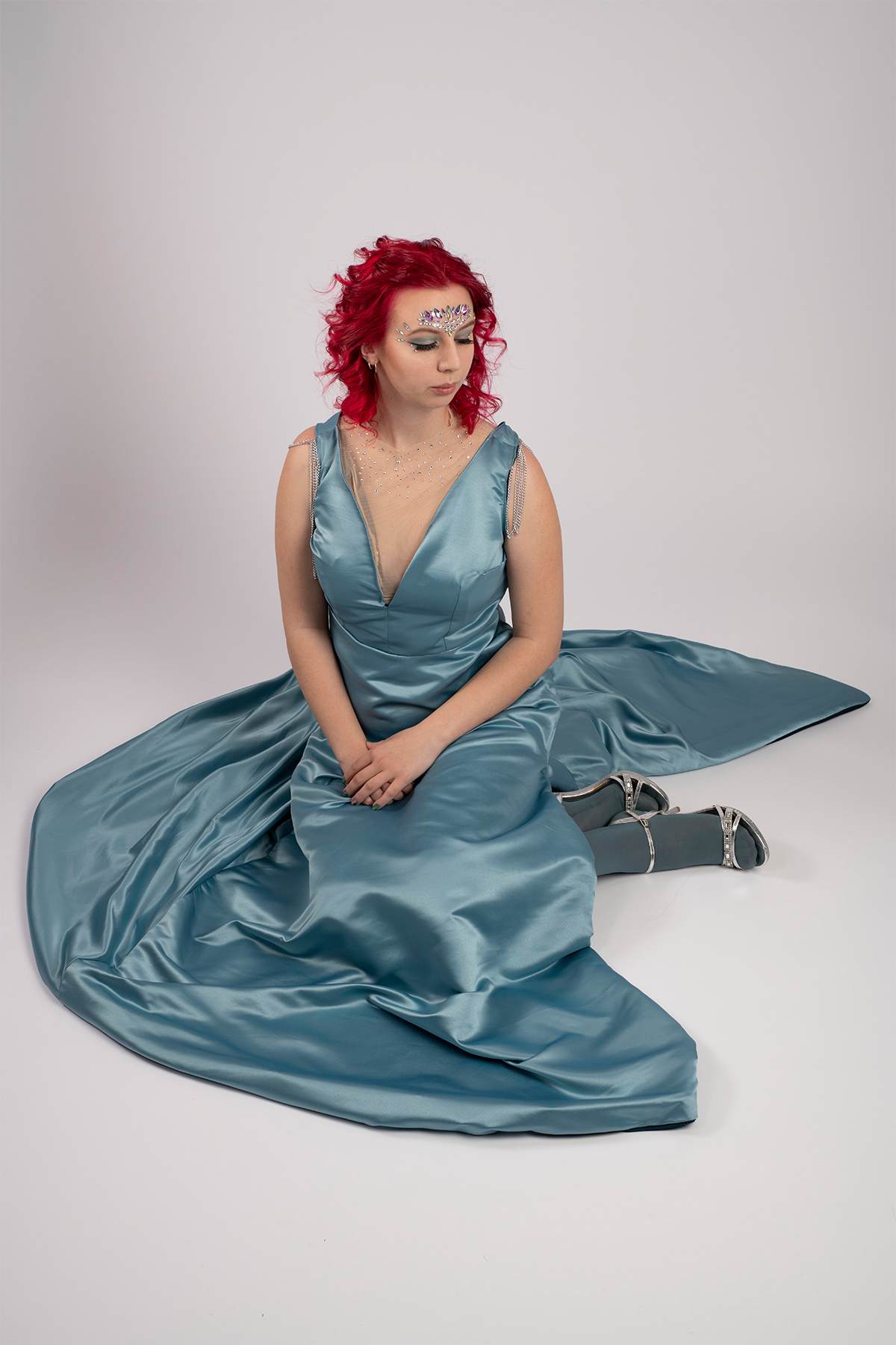 Payton Hatcher models a French blue floor-length gown with empire waistline, accented with plunging necklines with crystals.